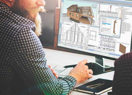 Un hombre viendo la pantalla de su computador donde hay planos y una maqueta de una edificación en madera